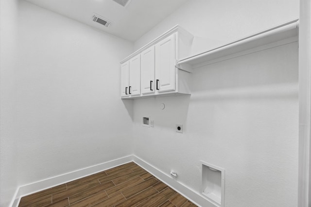 12126 Guadalupe Trail Ln, Humble, TX 77346 - laundry room featuring hookup for an electric dryer, wood finish floors, visible vents, cabinet space, and gas dryer hookup