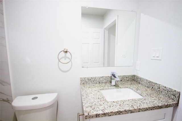 bathroom featuring toilet and vanity