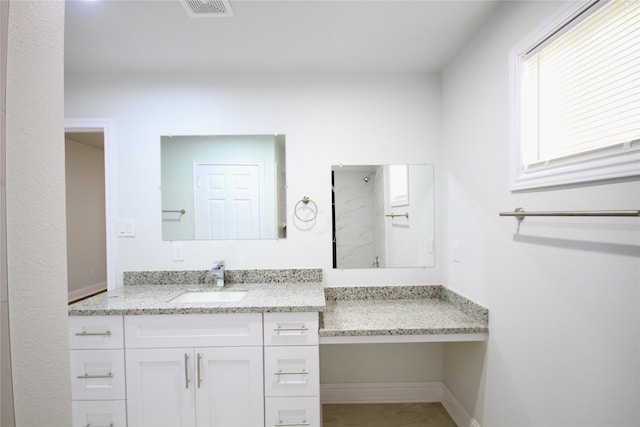 bathroom featuring a shower and vanity