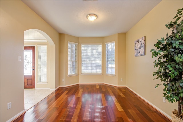 21122 Covington Bridge Dr, Spring, TX 77388 - unfurnished room featuring wood finished floors, plenty of natural light, and arched walkways