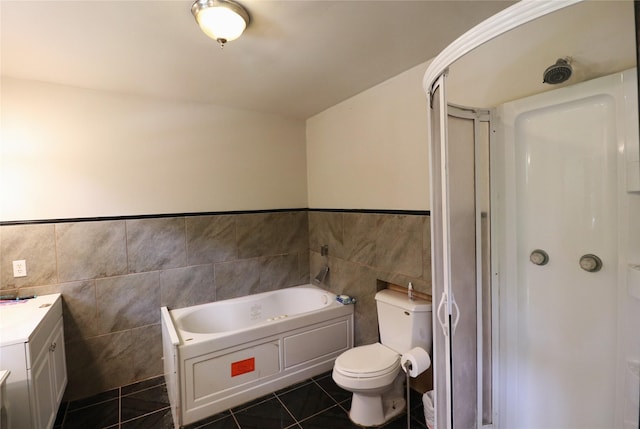 bathroom featuring tile patterned flooring, tile walls, toilet, a stall shower, and a bath