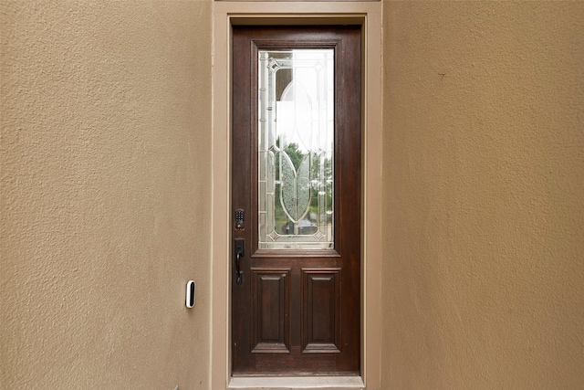 entrance to property featuring stucco siding
