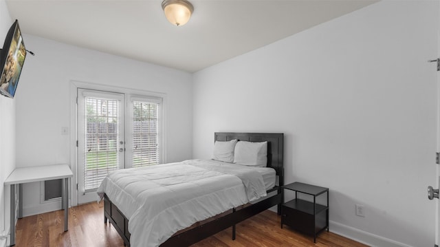 bedroom with access to outside, baseboards, and wood finished floors