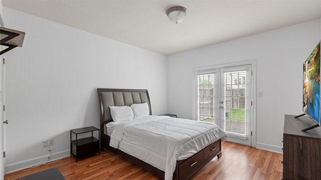 bedroom featuring light wood finished floors, baseboards, and access to outside