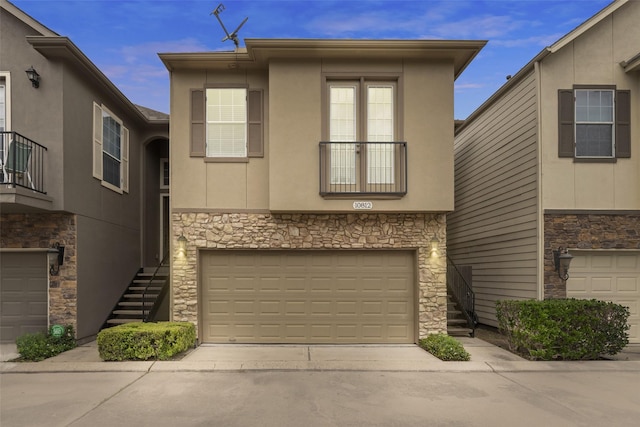 view of front of property with driveway, an attached garage, stone siding, and stairway