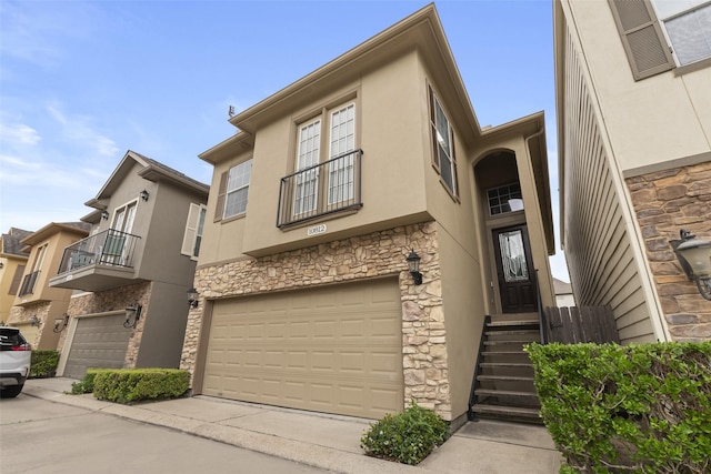 view of property featuring stucco siding, an attached garage, and stone siding