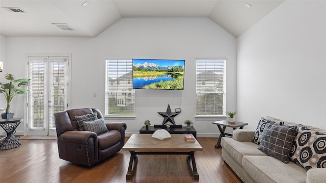 living room with a wealth of natural light, visible vents, and hardwood / wood-style flooring
