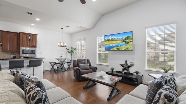 living area featuring vaulted ceiling, recessed lighting, ceiling fan with notable chandelier, dark wood-style floors, and visible vents