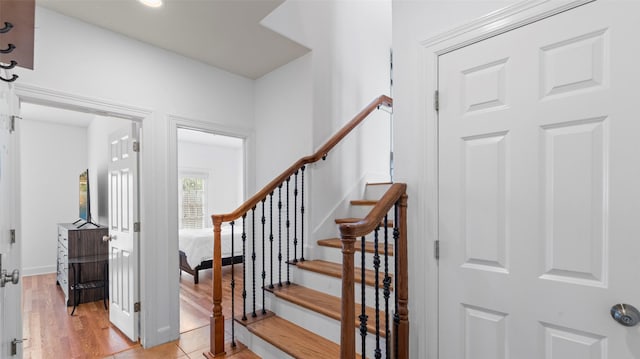 staircase featuring baseboards and wood finished floors