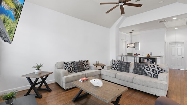 living room featuring visible vents, ceiling fan, wood finished floors, attic access, and vaulted ceiling