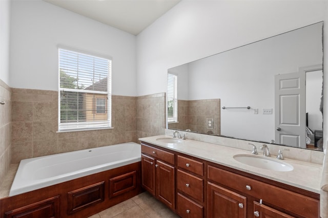 bathroom with double vanity, a bath, tile patterned flooring, and a sink