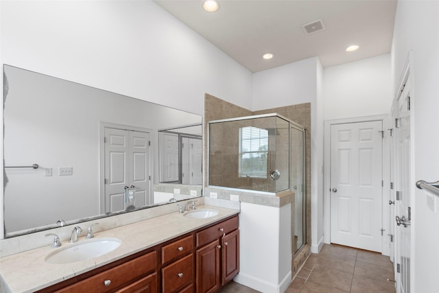 bathroom featuring visible vents, a sink, and a shower stall