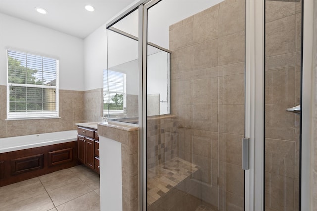 full bathroom with tile patterned flooring, vanity, a stall shower, and a garden tub