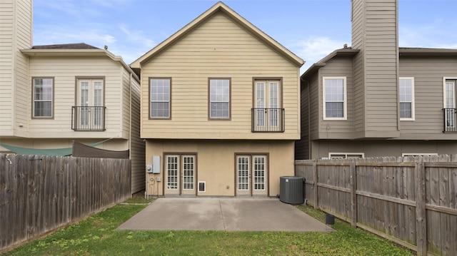 back of property featuring central air condition unit, a fenced backyard, a patio, and french doors