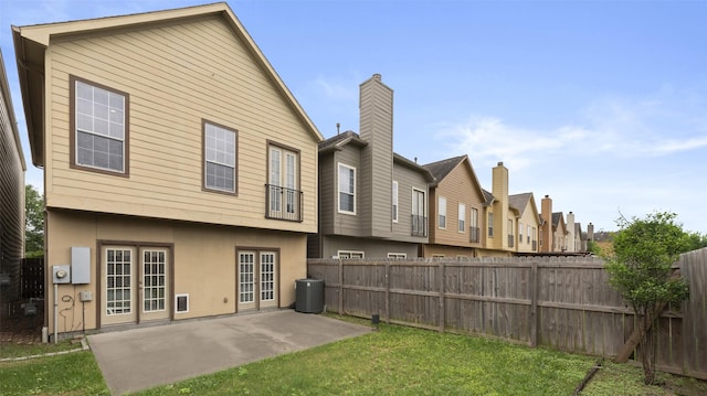 rear view of house featuring fence, stucco siding, a patio area, and a yard