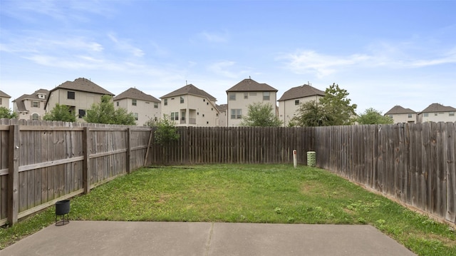 view of yard featuring a fenced backyard and a residential view