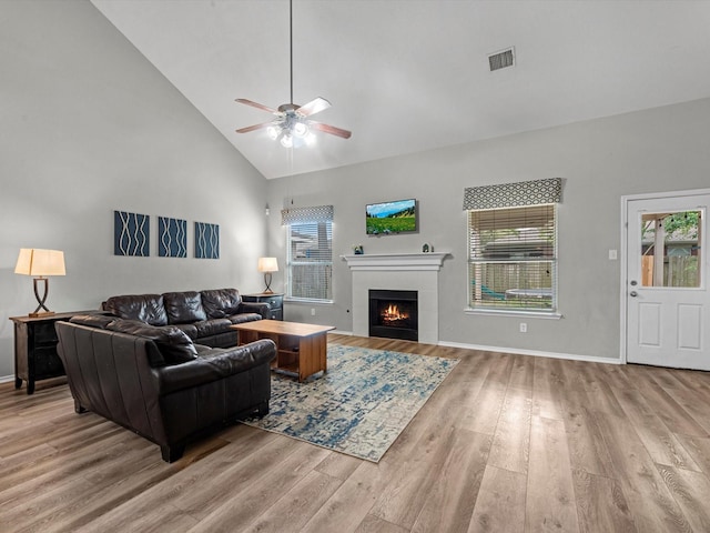 13923 Roanoke Falls Dr, Cypress, TX 77429 - living area with wood finished floors, a ceiling fan, high vaulted ceiling, a tile fireplace, and baseboards