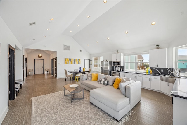 3910 Palmdale Ct, Galveston, TX 77554 - living area featuring recessed lighting, high vaulted ceiling, visible vents, and light wood-style floors