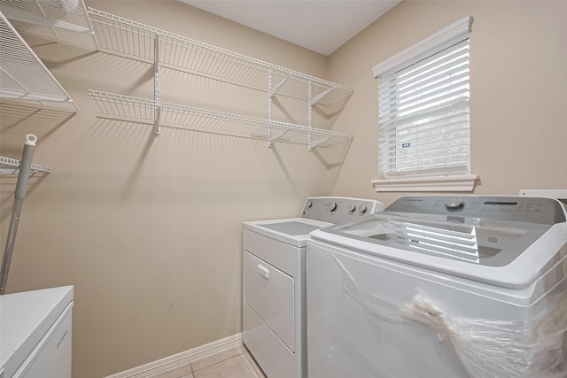 1218 Ventura Canyon Dr, Katy, TX 77494 - laundry area featuring light tile patterned floors, baseboards, washer and dryer, and laundry area
