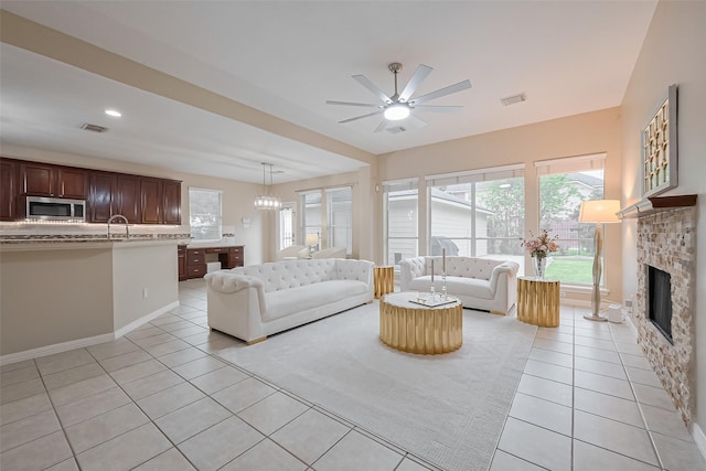 1218 Ventura Canyon Dr, Katy, TX 77494 - unfurnished living room with a glass covered fireplace, light tile patterned floors, a ceiling fan, visible vents, and a sink