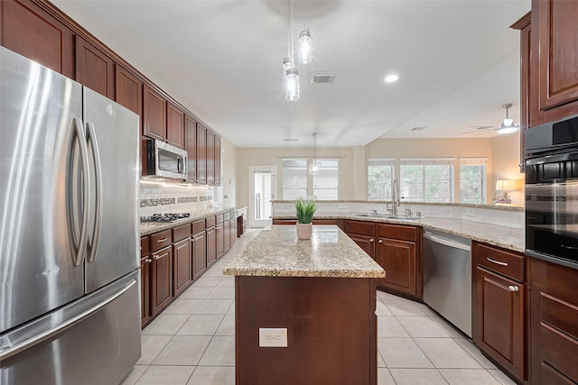 1218 Ventura Canyon Dr, Katy, TX 77494 - kitchen featuring light tile patterned floors, visible vents, a kitchen island, appliances with stainless steel finishes, and a sink