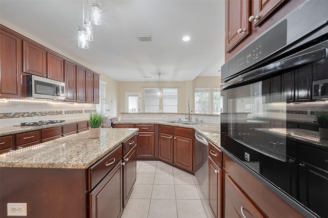 1218 Ventura Canyon Dr, Katy, TX 77494 - kitchen with light tile patterned floors, visible vents, a sink, stainless steel appliances, and decorative light fixtures
