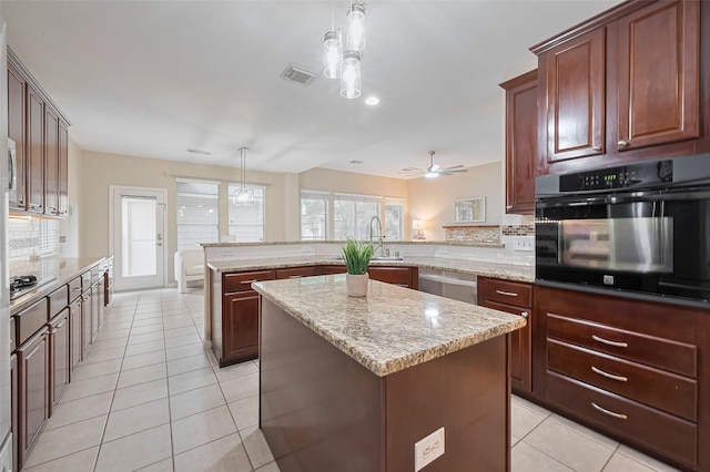1218 Ventura Canyon Dr, Katy, TX 77494 - kitchen featuring tasteful backsplash, light tile patterned floors, appliances with stainless steel finishes, a peninsula, and a kitchen island