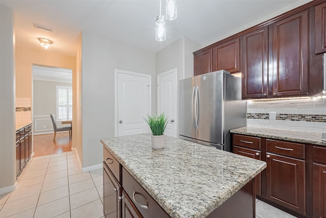 1218 Ventura Canyon Dr, Katy, TX 77494 - kitchen with light tile patterned floors, freestanding refrigerator, light stone countertops, decorative backsplash, and a kitchen island