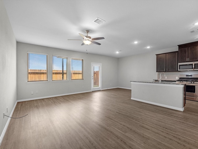 kitchen with dark brown cabinetry, a ceiling fan, wood finished floors, and stainless steel appliances