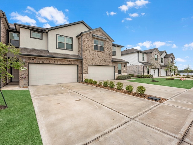 view of front of property with a residential view, driveway, an attached garage, a front yard, and stucco siding