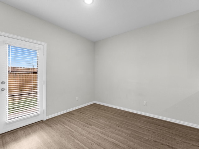 unfurnished room with baseboards and wood finished floors