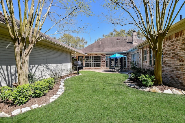 view of grassy yard featuring a patio area