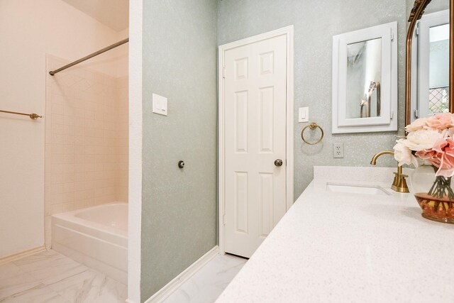 full bath with marble finish flooring, baseboards, and washtub / shower combination