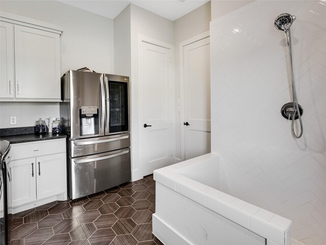 10114 Mariner Oaks Dr, Missouri City, TX 77459 - kitchen with white cabinetry, stainless steel refrigerator with ice dispenser, and dark tile patterned flooring