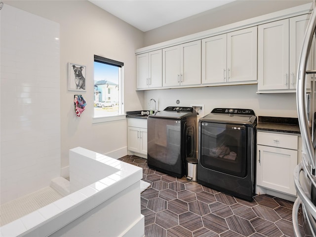 10114 Mariner Oaks Dr, Missouri City, TX 77459 - washroom with cabinet space, a sink, washer and dryer, and dark tile patterned floors