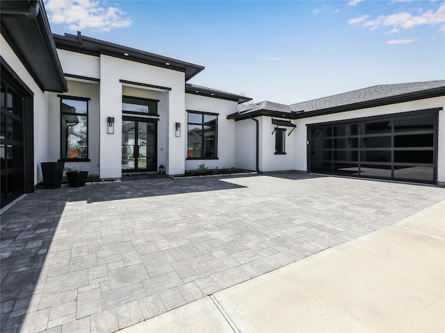 10114 Mariner Oaks Dr, Missouri City, TX 77459 - view of front facade with driveway, stucco siding, an attached garage, and french doors