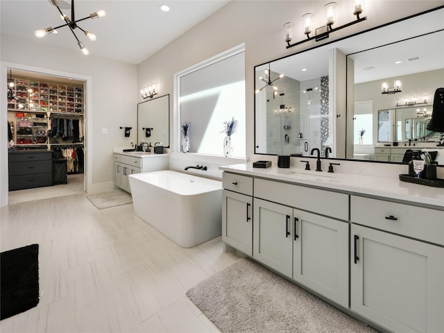 10114 Mariner Oaks Dr, Missouri City, TX 77459 - full bath with a freestanding tub, two vanities, a sink, a stall shower, and a notable chandelier