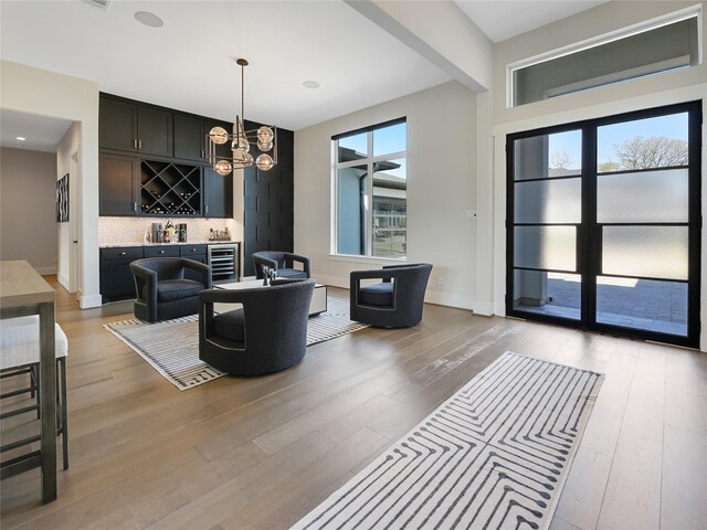 10114 Mariner Oaks Dr, Missouri City, TX 77459 - living area featuring light wood-style flooring, wine cooler, and an inviting chandelier