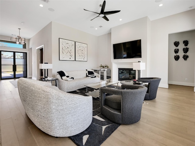 10114 Mariner Oaks Dr, Missouri City, TX 77459 - living area featuring baseboards, wood finished floors, recessed lighting, ceiling fan with notable chandelier, and a glass covered fireplace