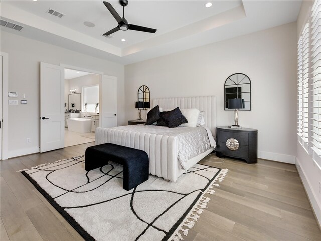10114 Mariner Oaks Dr, Missouri City, TX 77459 - bedroom with light wood finished floors, visible vents, and a raised ceiling