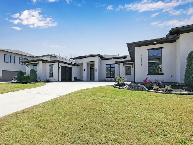 10114 Mariner Oaks Dr, Missouri City, TX 77459 - view of front of house featuring stucco siding, a garage, concrete driveway, and a front yard
