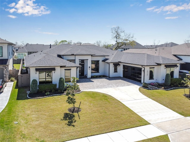 10114 Mariner Oaks Dr, Missouri City, TX 77459 - view of front facade featuring a front yard, decorative driveway, a garage, and stucco siding