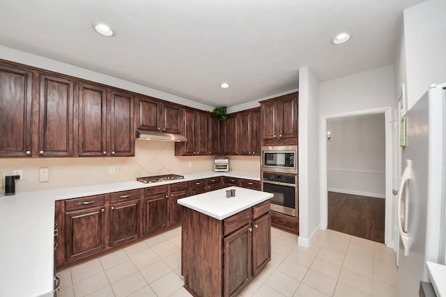 313 Overlook Dr, Friendswood, TX 77546 - kitchen with light countertops, recessed lighting, light tile patterned floors, stainless steel appliances, and under cabinet range hood