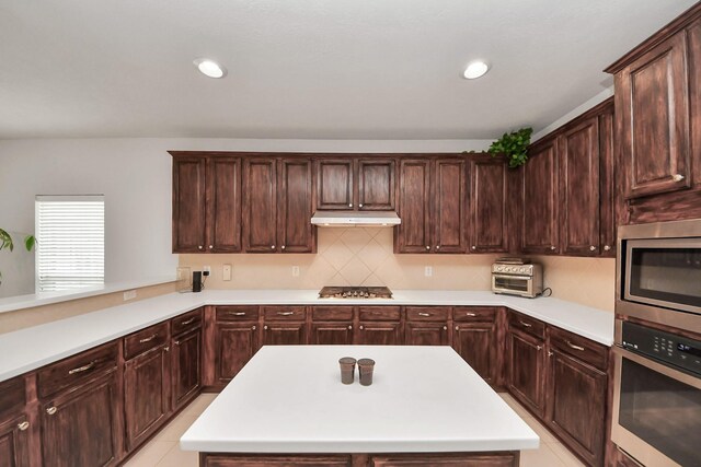 313 Overlook Dr, Friendswood, TX 77546 - kitchen featuring light countertops, under cabinet range hood, and stainless steel appliances