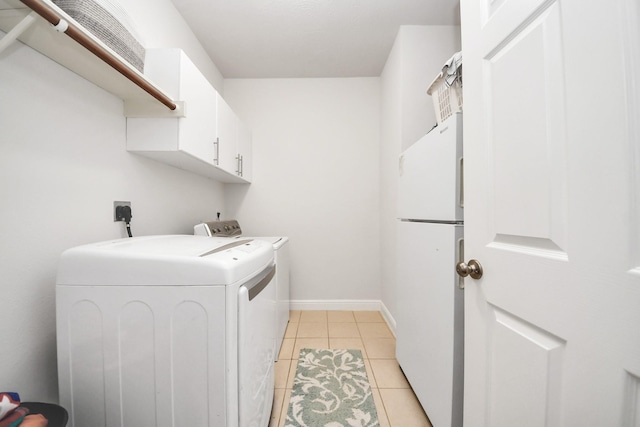 313 Overlook Dr, Friendswood, TX 77546 - washroom featuring light tile patterned flooring, washer and clothes dryer, cabinet space, and baseboards