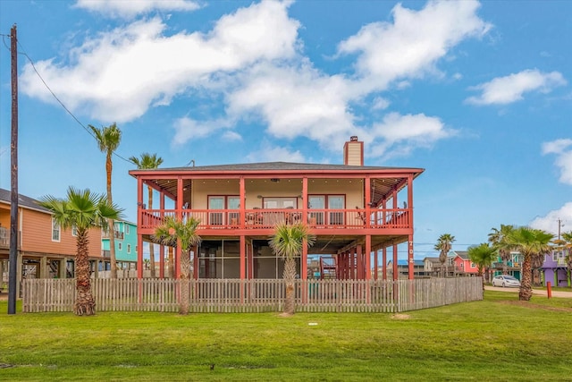702 Surf Dr, Surfside Beach, TX 77541 - back of property with a yard, fence private yard, and a chimney