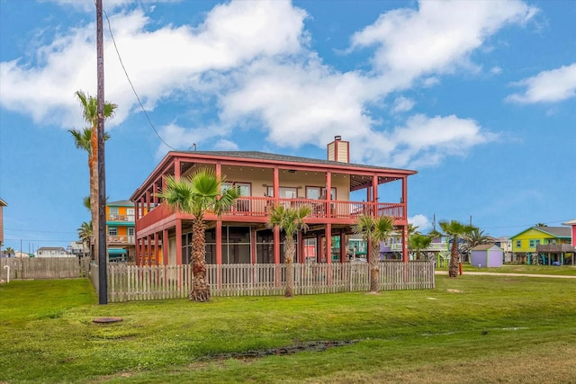 702 Surf Dr, Surfside Beach, TX 77541 - back of property with fence, a chimney, and a lawn