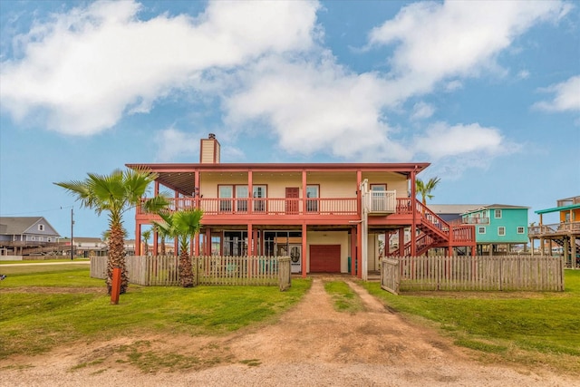 702 Surf Dr, Surfside Beach, TX 77541 - back of house with a lawn, driveway, a chimney, and a garage