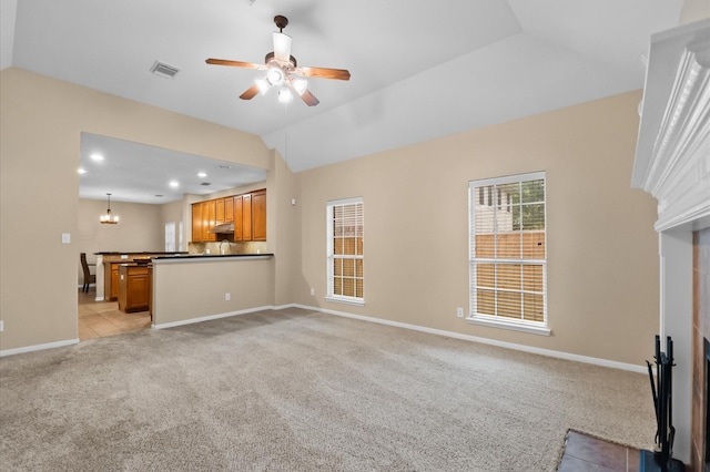 unfurnished living room with visible vents, ceiling fan, baseboards, vaulted ceiling, and light carpet