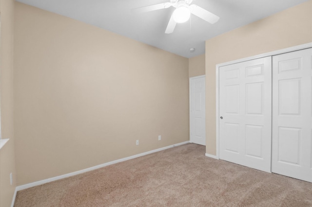 unfurnished bedroom with light colored carpet, ceiling fan, baseboards, and a closet